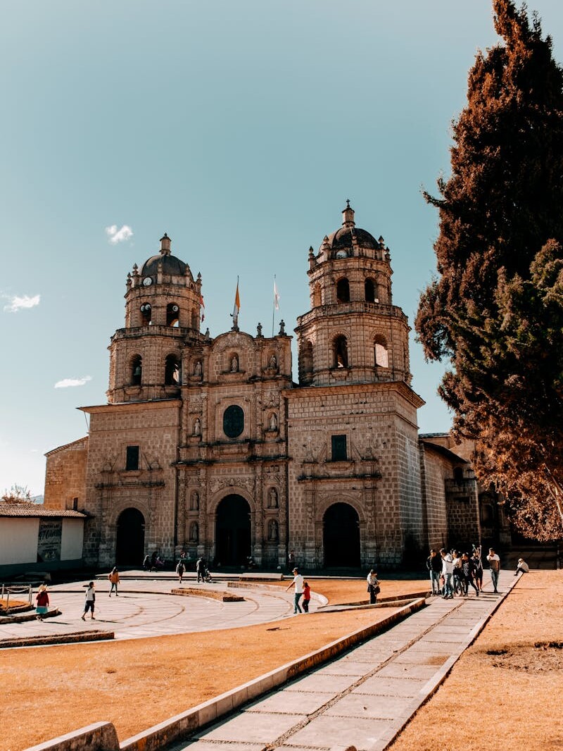 Stunning exterior view of the historic cathedral in Cajamarca, Peru with tourists exploring.