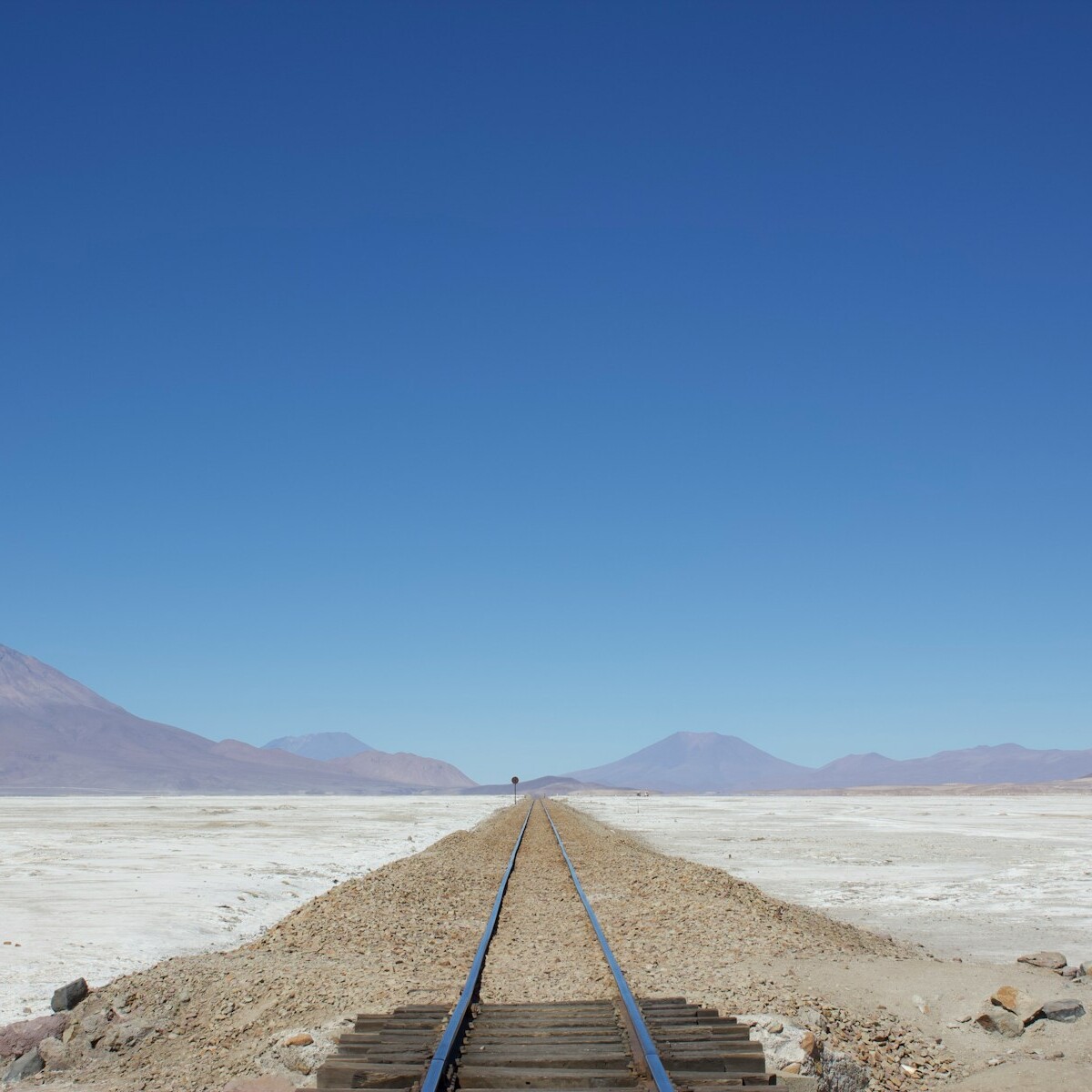 a train track with a mountain in the background