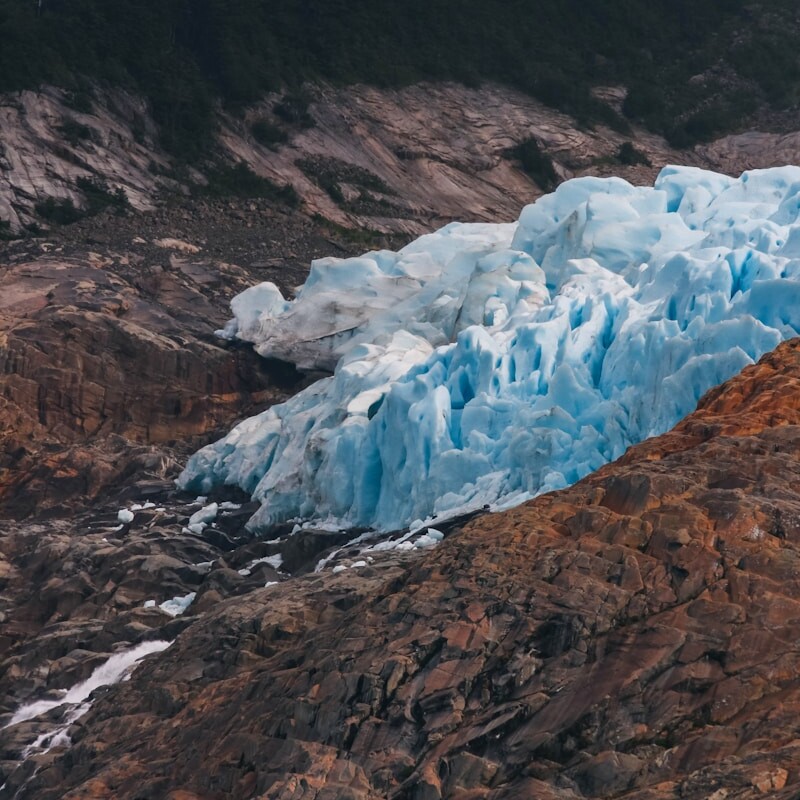 a large blue iceberg sitting on the side of a mountain