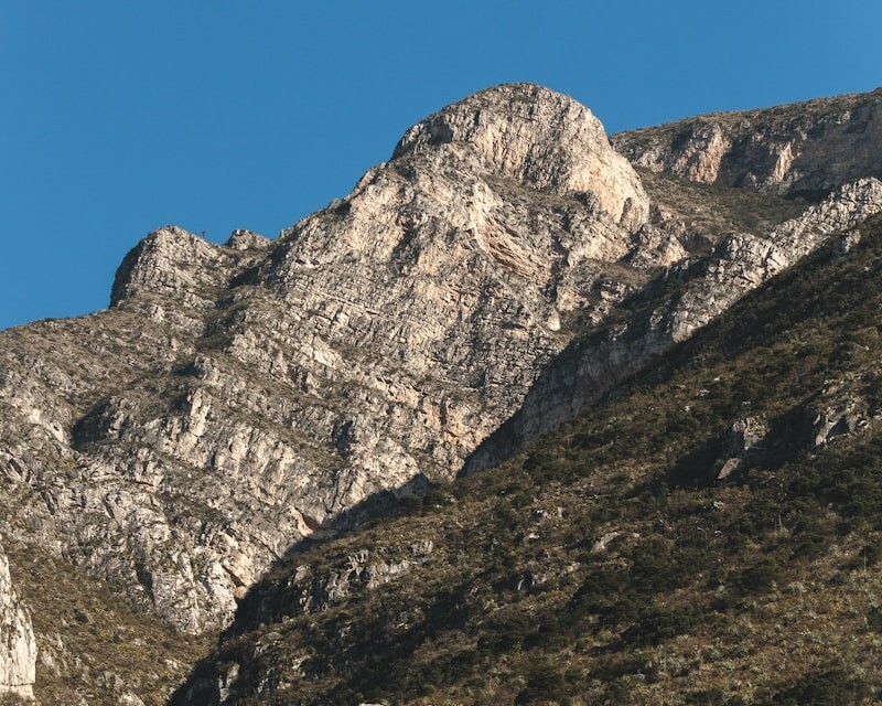 a rocky mountain with a blue sky