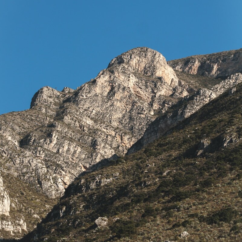 a rocky mountain with a blue sky